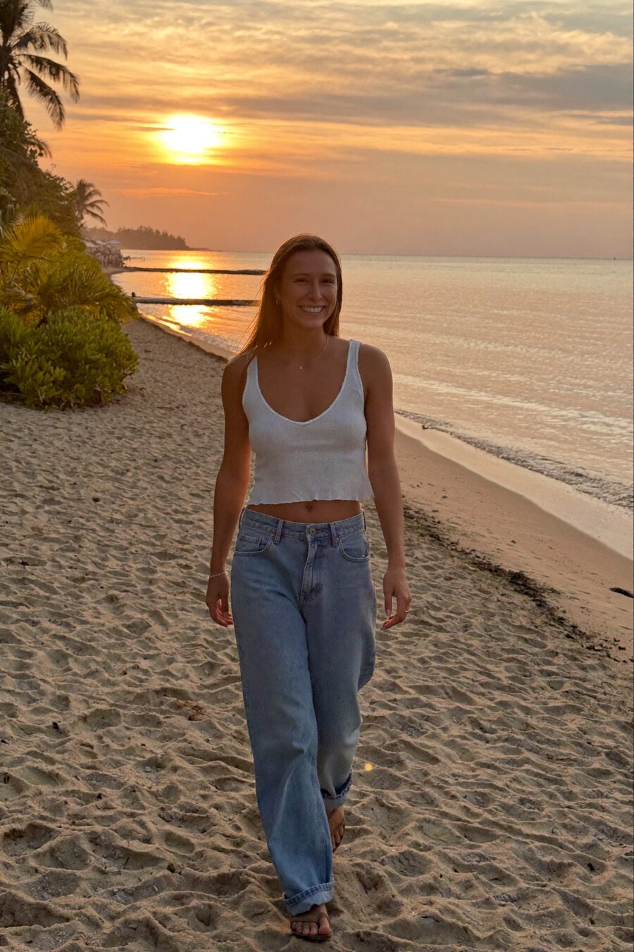 Marta de espaldas mirando al mar al atardecer